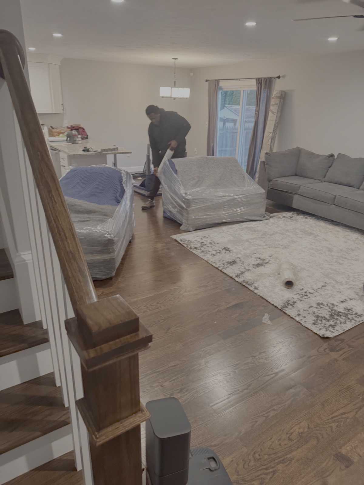 Mover preparing furniture with blankets and stretch wrap